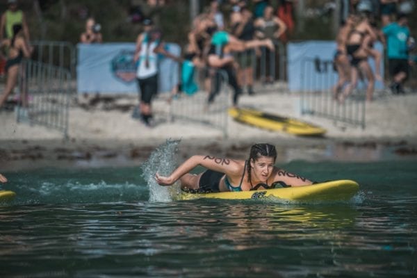 The Bay Games : girl hand paddling on surf board